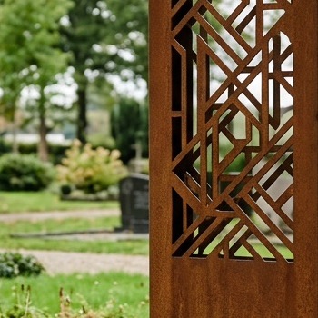 Close-up van een uitgesneden geometrisch motief in cortenstaal